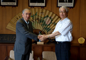 握手を交わす杉村理事長（左）と野口医学部長